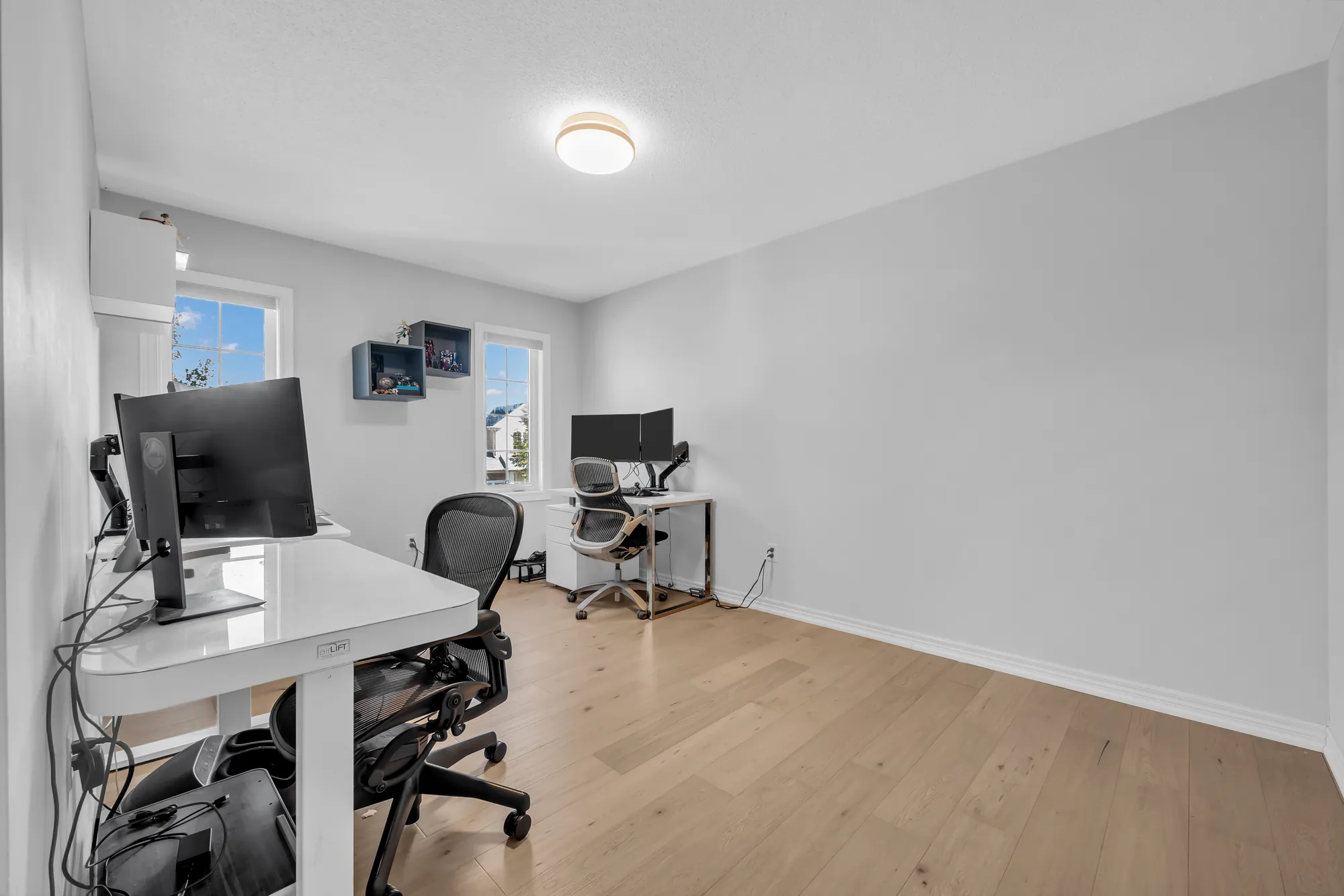 The same room from the other side, a desk in the foreground, the window and the door beyond